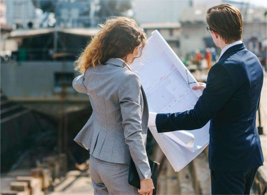 woman and man holding blueprint